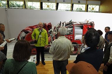 リチャード館長,後ろは津波で大破した消防車両