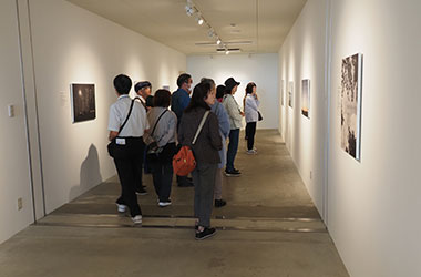 被災した方々思いに触れる展示を見つめる参加者